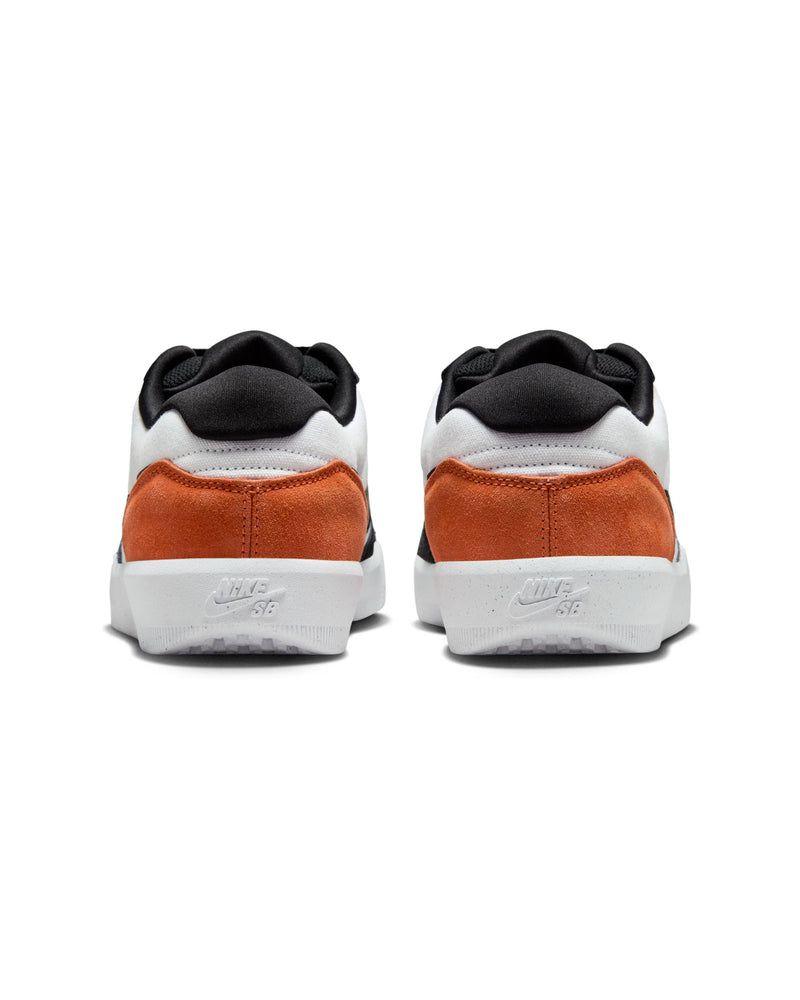 Rear view of low-top sneakers with orange suede heels, black collars, white panels, and "Nike SB" branding on white rubber soles.