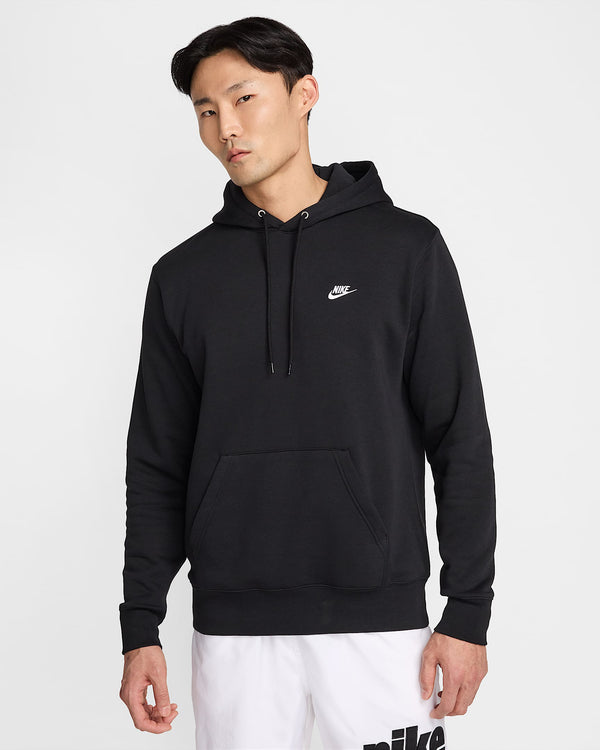 Front view of a man wearing a black Nike hoodie with white logo and white shorts.