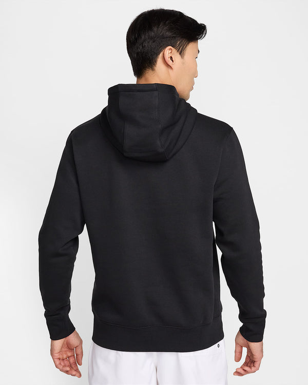 Back view of a black Nike hoodie with hood up, worn by a man in white shorts.