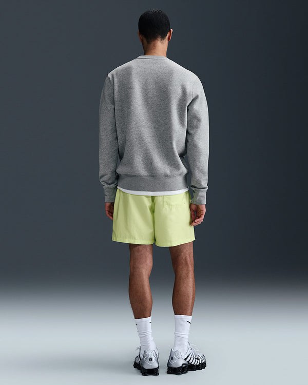 Back view of grey Nike fleece jumper paired with neon shorts, socks and sneakers