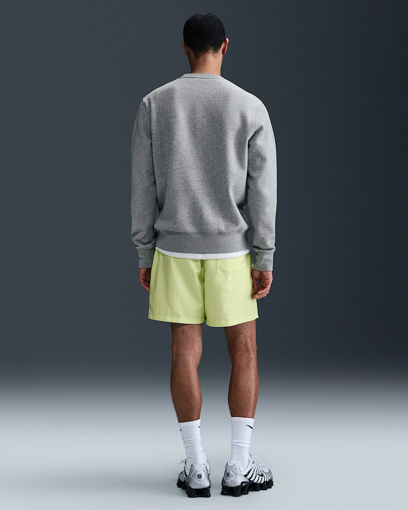 Back view of grey Nike fleece jumper paired with neon shorts, socks and sneakers