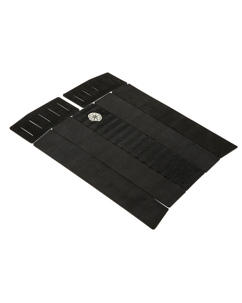 Angled view of black six-piece grip pad with arched centre section and textured slotted kick pads.
