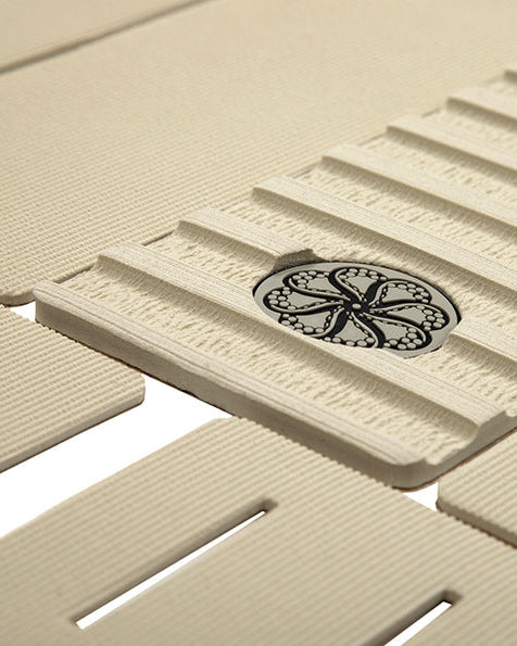 Close-up of centre ridge texture with black circular traction logo on beige front deck grip