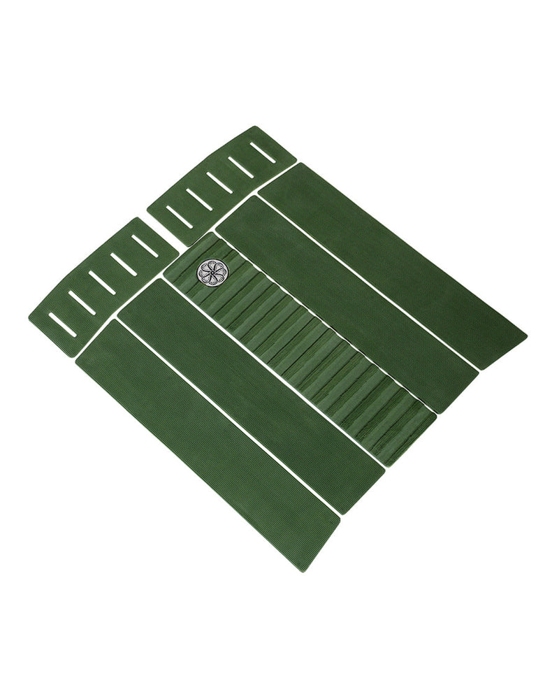 Angled view of green traction pad showing ribbed grip sections and slotted cutouts on front pads.