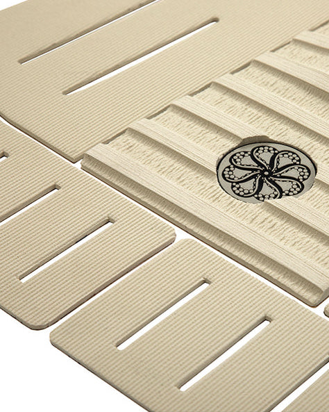 Close-up of textured traction pad with black circular logo and deep-cut slotted grooves