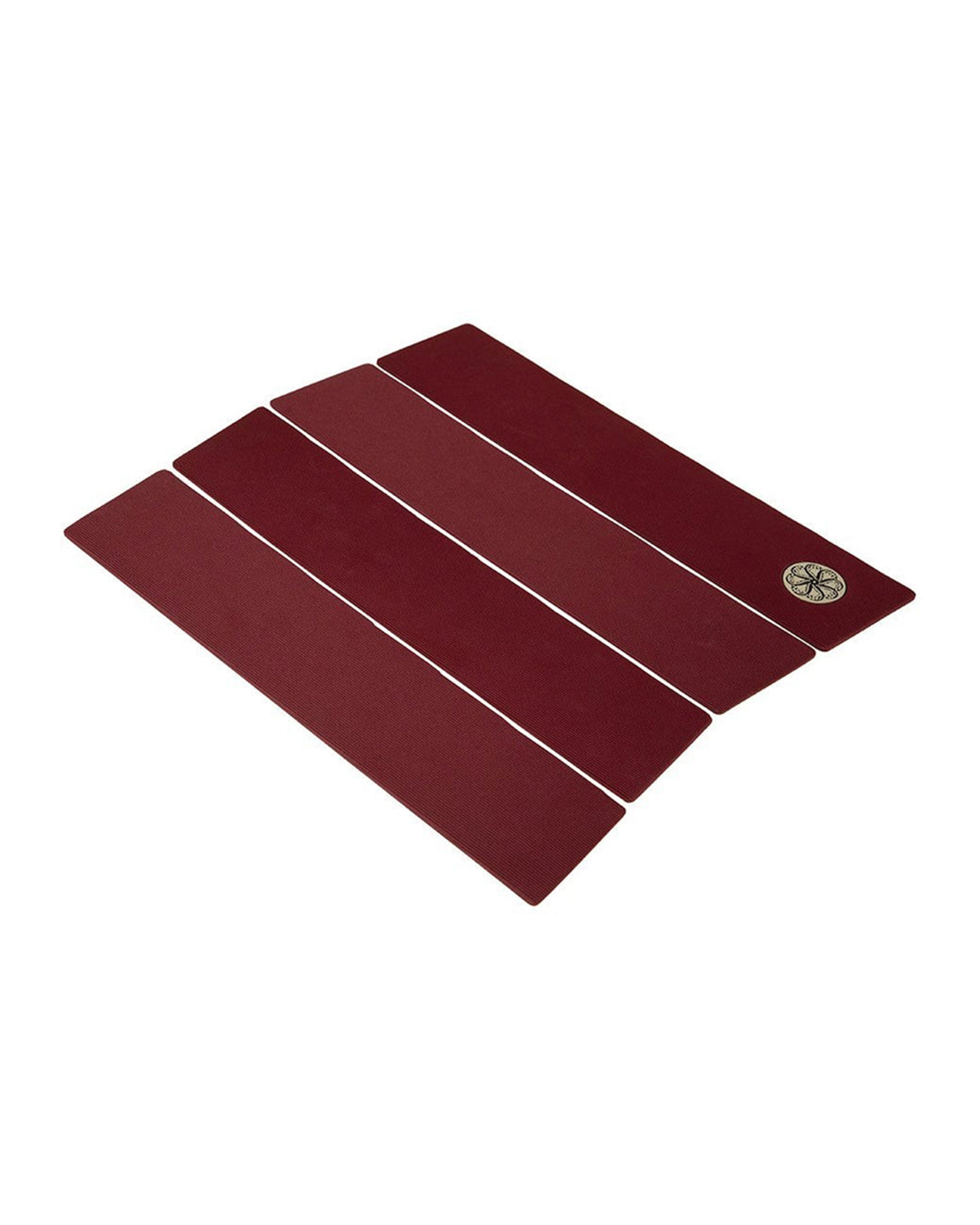 Angled top-down view of maroon four-piece surfboard grip with minimal texture.