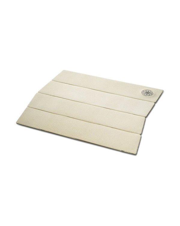 Angled view of white four-piece traction pad with ribbed grip texture and embossed logo.