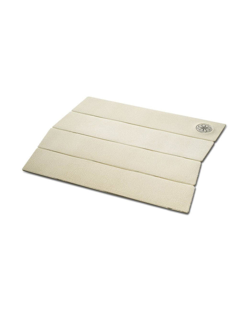Angled view of white four-piece traction pad with ribbed grip texture and embossed logo.