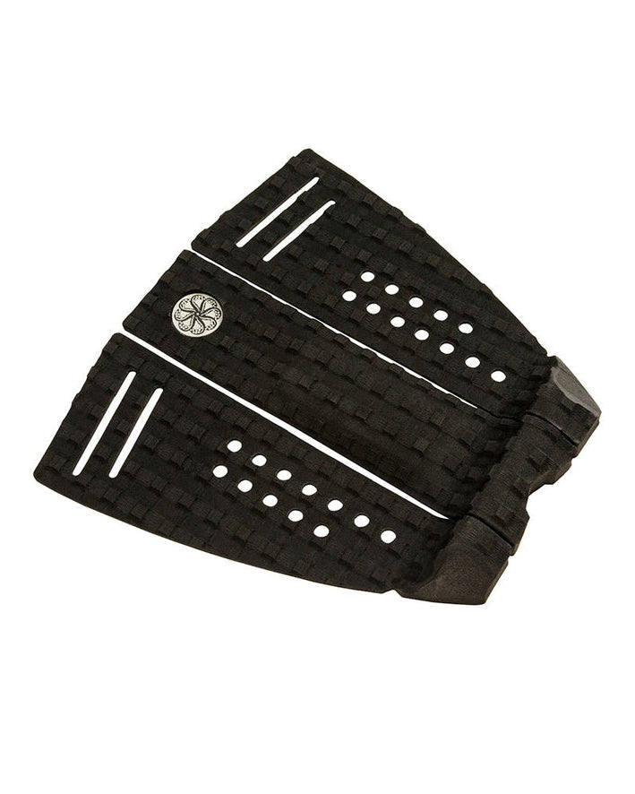 Angled view of black surfboard grip pad with perforations and textured pattern.