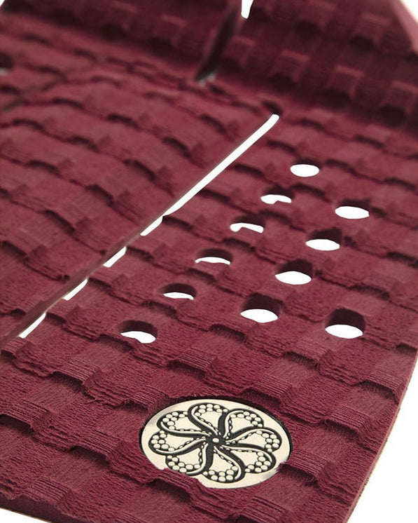 Close-up of burgundy traction pad texture and logo detailing.