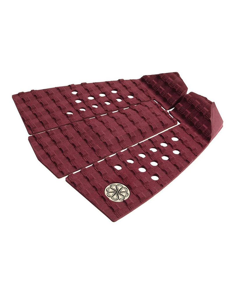 Side view of burgundy tail pad with raised kick and perforated grip sections.