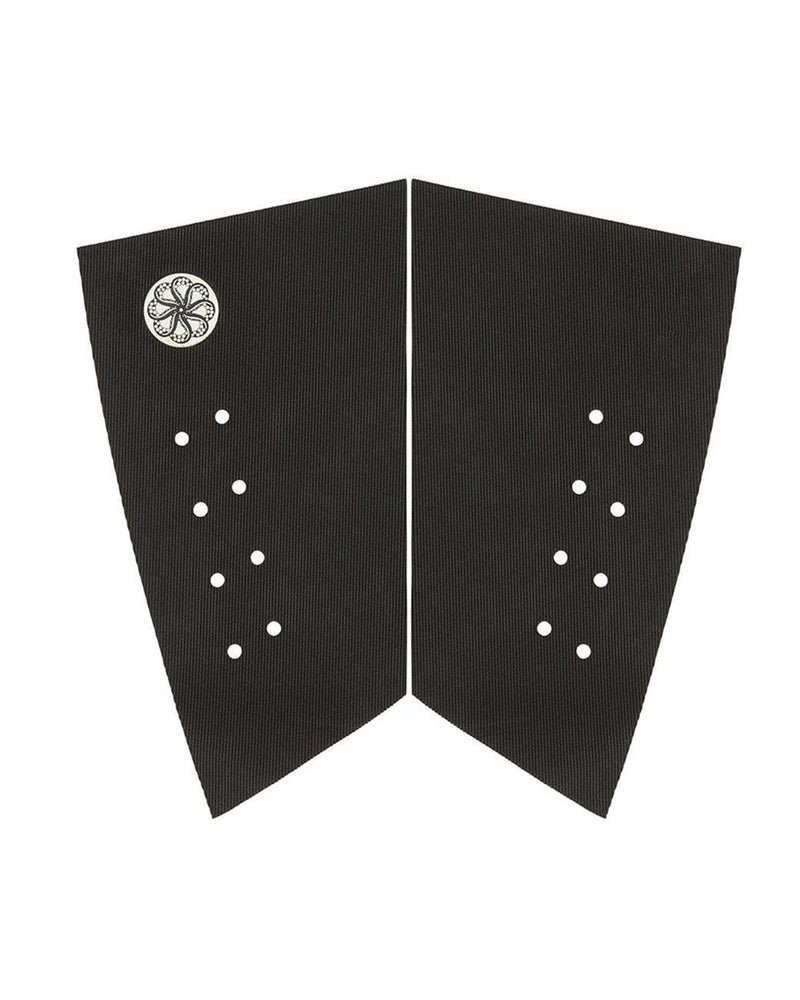 Two-piece black surfboard pad with angled edges, perforated grip holes, and small circular logo detail.