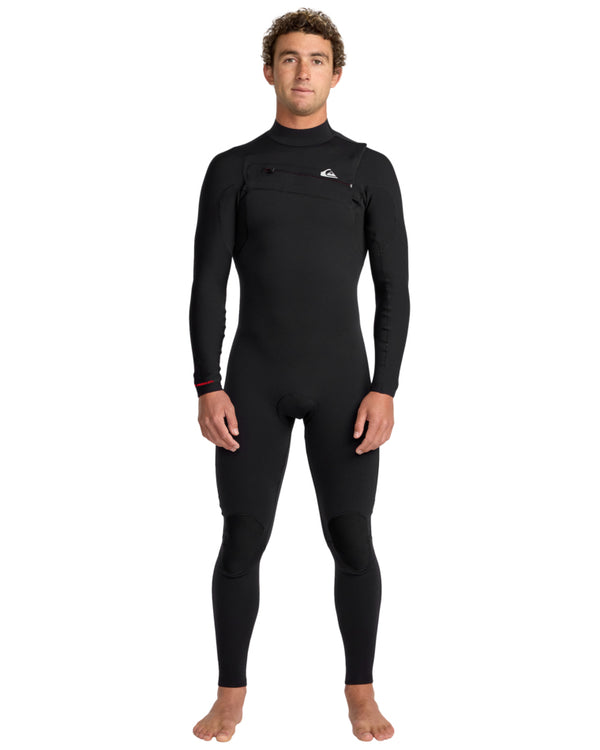 Man wearing a black full-length Quiksilver wetsuit with front chest zip, standing facing forward.