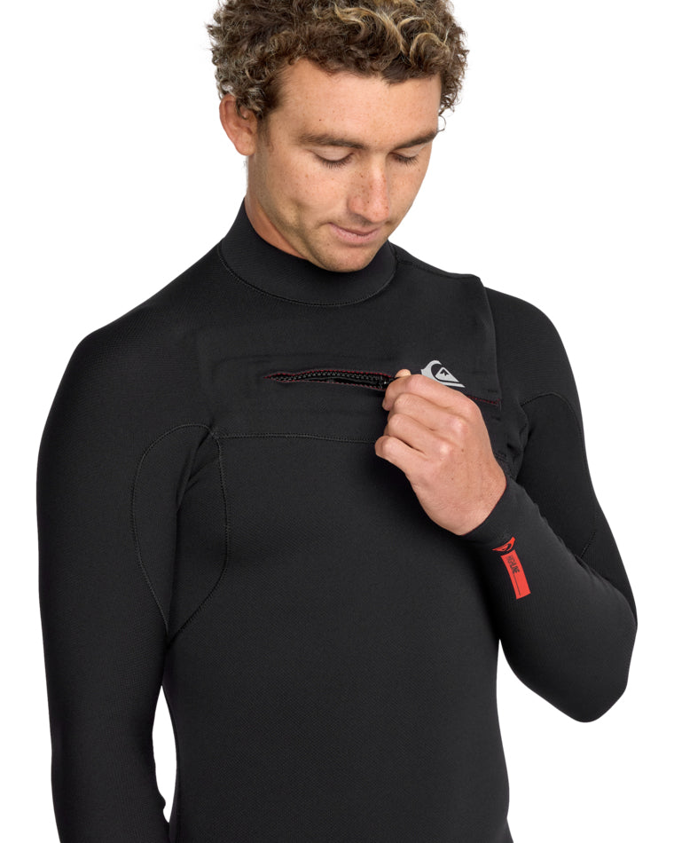 Close-up of chest zip on the Quiksilver wetsuit, model unzipping with visible logo and red zipper pull.