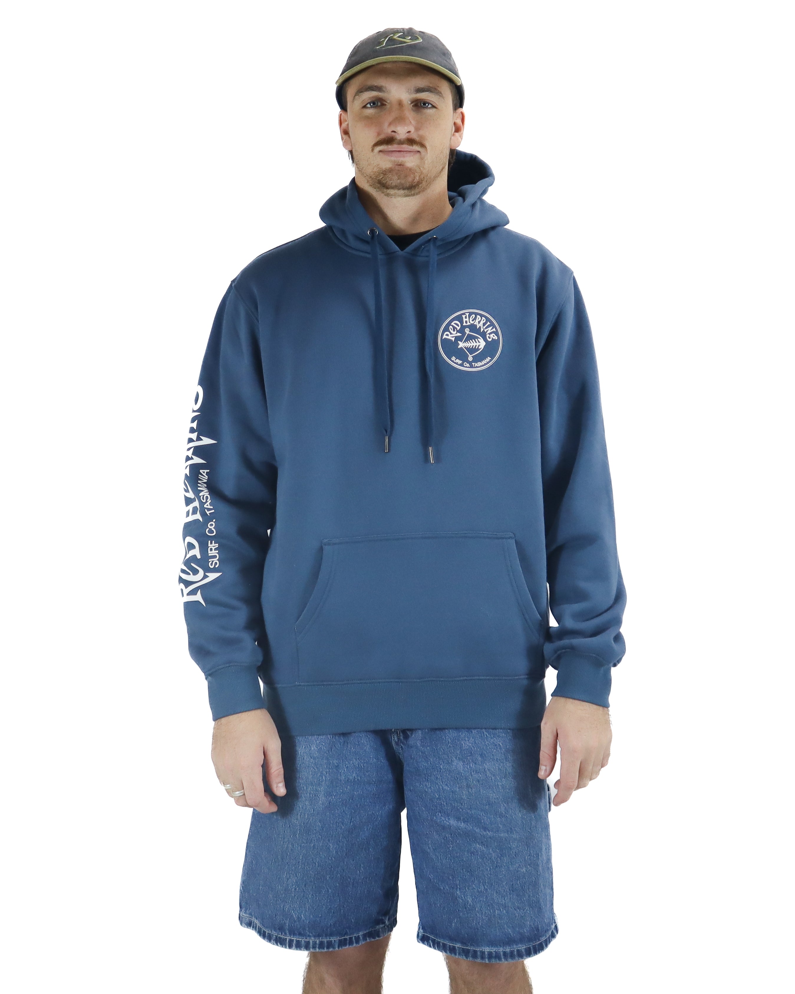 Front view of a blue Red Herring hoodie with chest logo, sleeve print, and kangaroo pocket, styled with denim shorts.