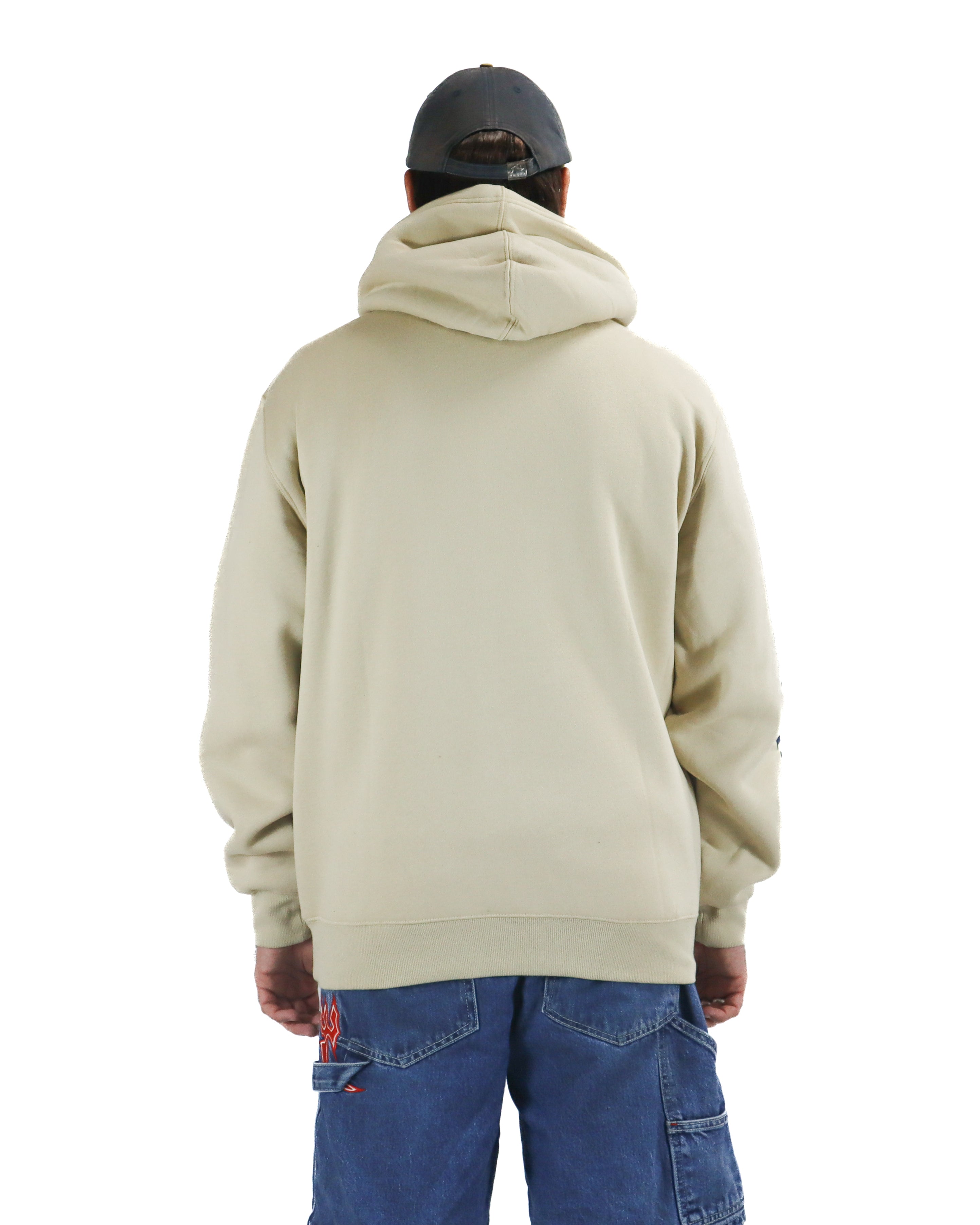 Back view of a man wearing a beige hoodie and blue cargo jeans with flame embroidery and a grey cap.