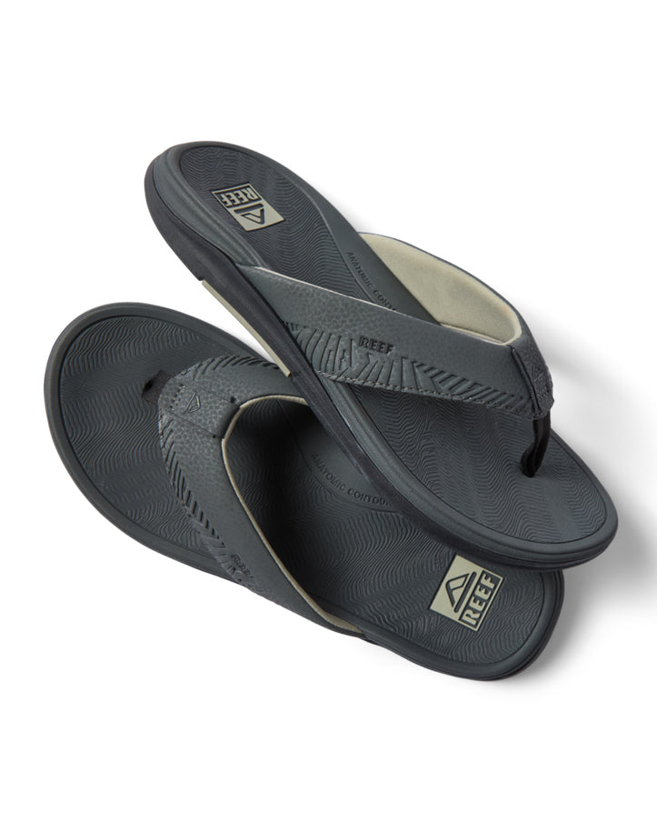 Angled view of Reef grey sandals stacked, showing textured straps and logo footbed
