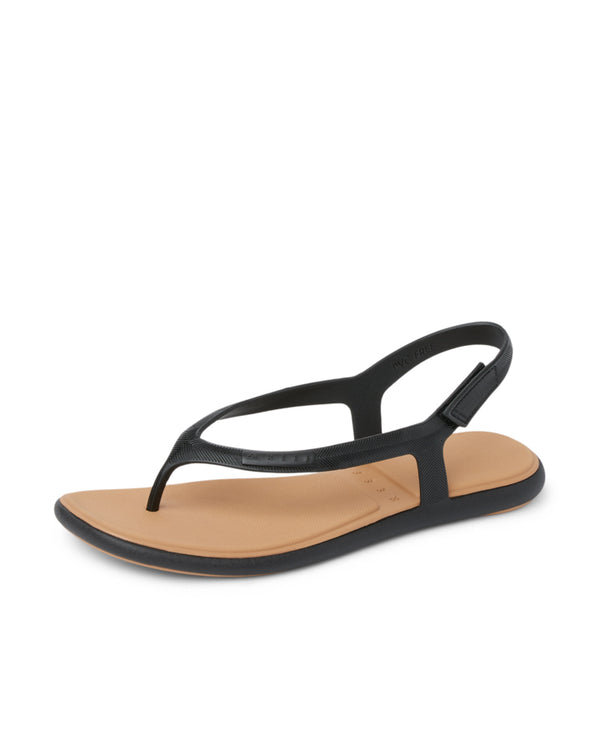 Black thong sandals with tan footbed, angled view.