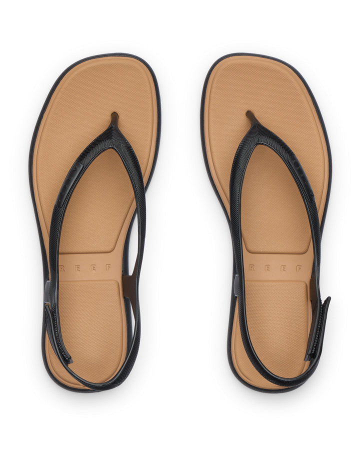 Black thong sandals with tan footbed, top view.