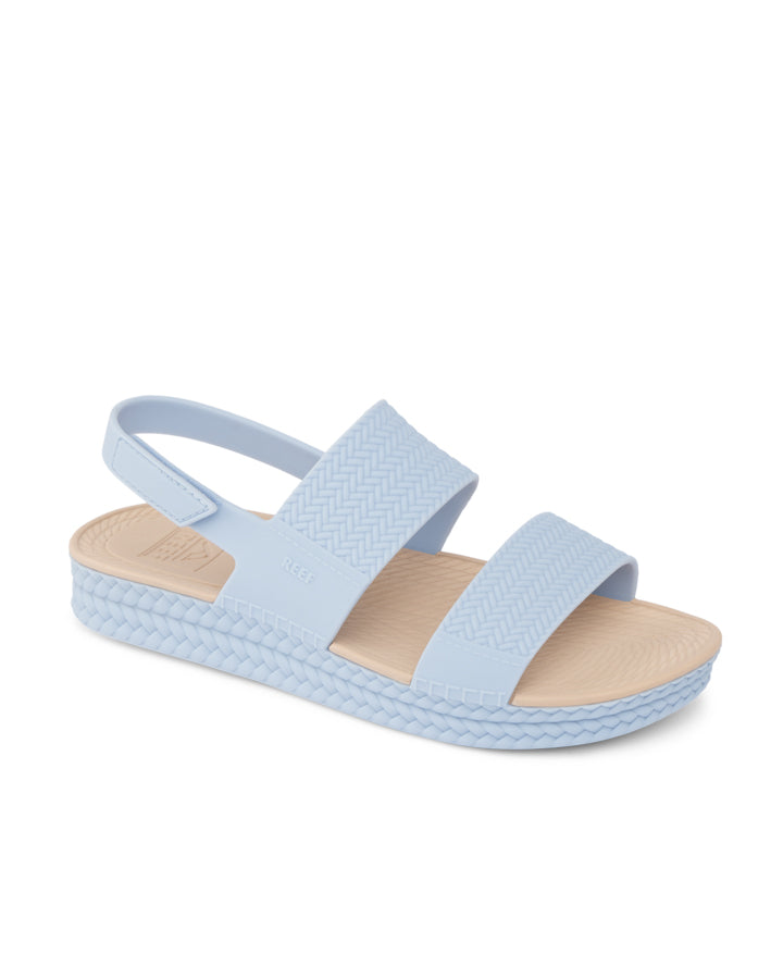 Women's light blue Reef sandals with dual straps and slingback design, side profile view