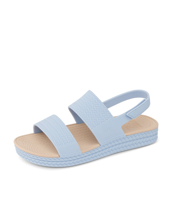 Reef slingback sandals in pastel blue with textured footbed and arch support, angled view