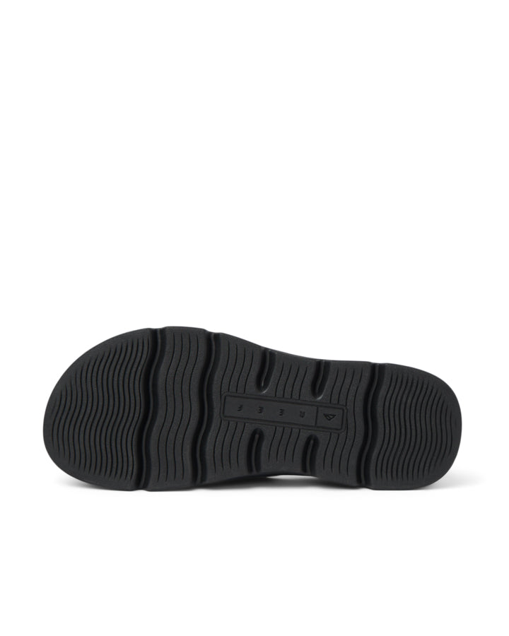 Bottom of black sandal showing grooved, non-slip outsole with Reef logo