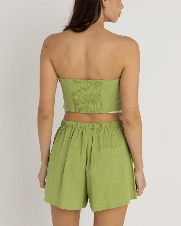 Back view of a strapless green top with smocked detailing and white trim, paired with matching green shorts featuring a pocket.