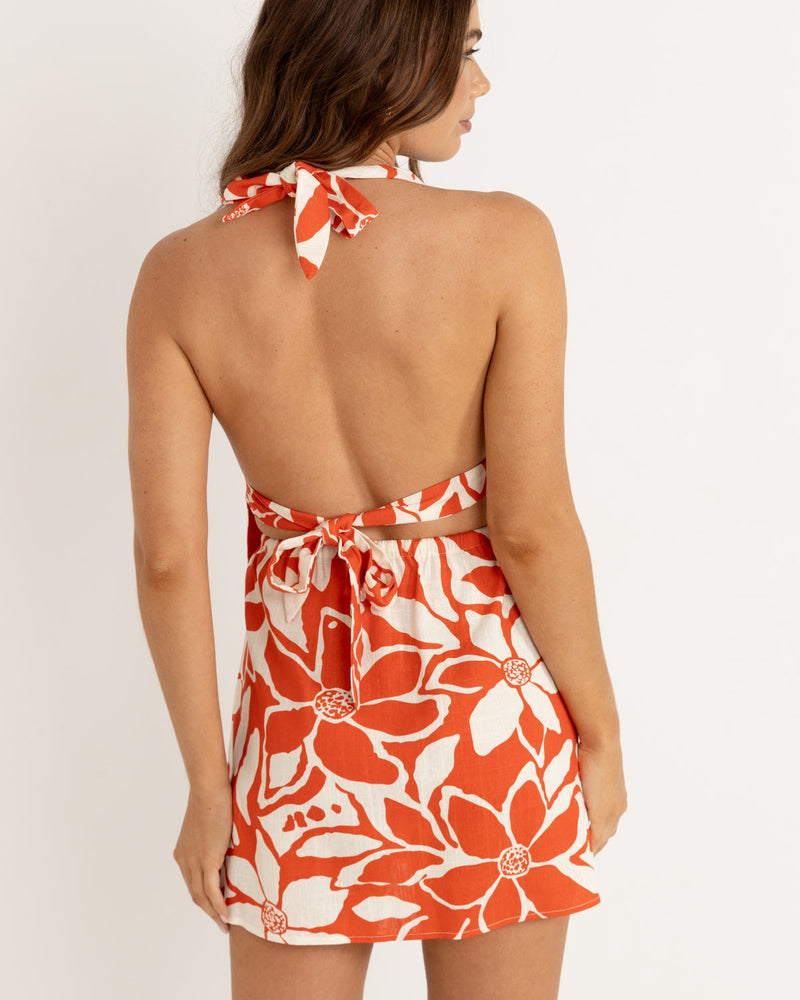 Back view of a red and white floral halter top with an open back design, tied at the neck and waist for a relaxed summer look.