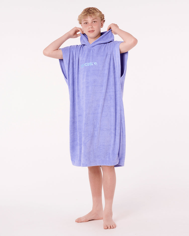Boy wearing a purple Rip Curl hooded towel with logo on chest.