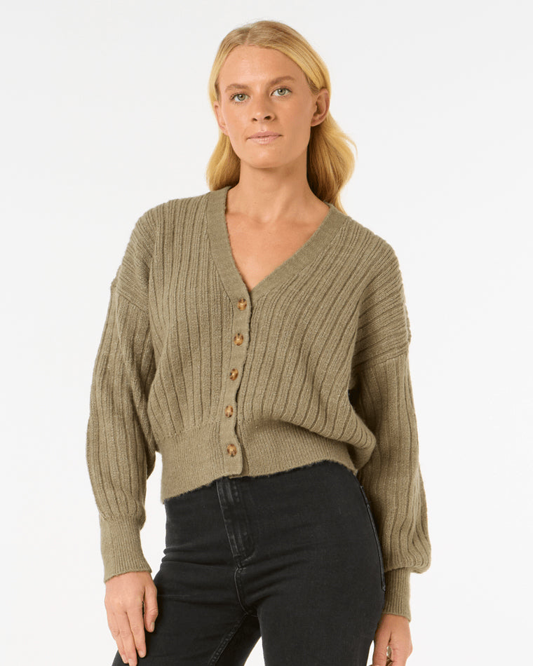 Model wearing an olive green ribbed knit cardigan with button-down front and balloon sleeves, paired with black jeans.