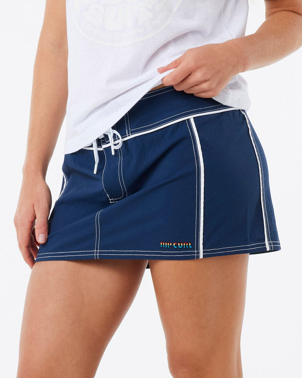 Navy blue Rip Curl skirt with white stitching, adjustable drawstring waist, and a sporty design.