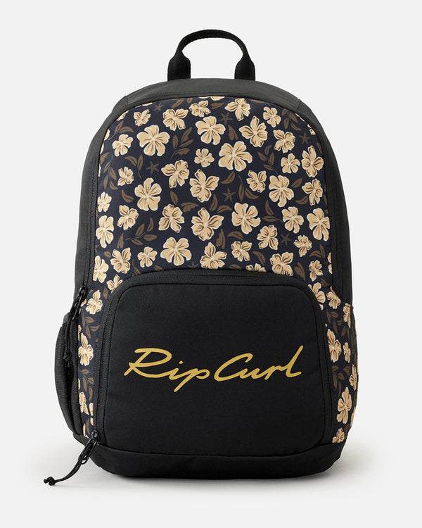 Black Rip Curl backpack featuring a beige floral pattern, a front zippered pocket with a cursive logo, and a top carry handle.