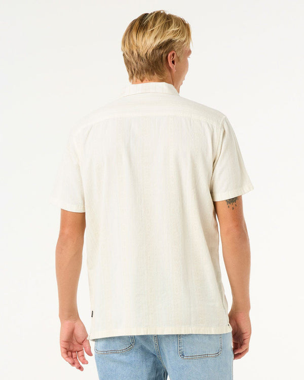 Back view of cream textured shirt in relaxed fit paired with light blue jeans.