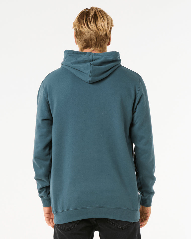 Back view of a man wearing a teal Rip Curl hoodie with a relaxed fit, featuring a hood and ribbed cuffs and hem.