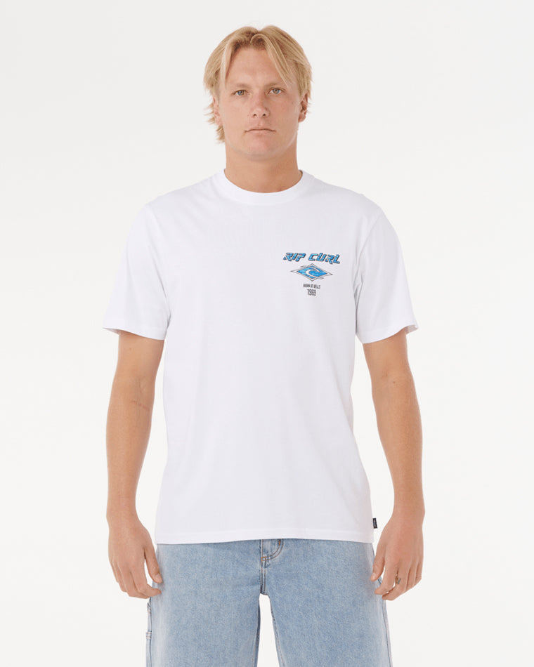 Model wearing a white Rip Curl t-shirt with a small blue graphic logo on the chest, paired with light blue denim shorts.