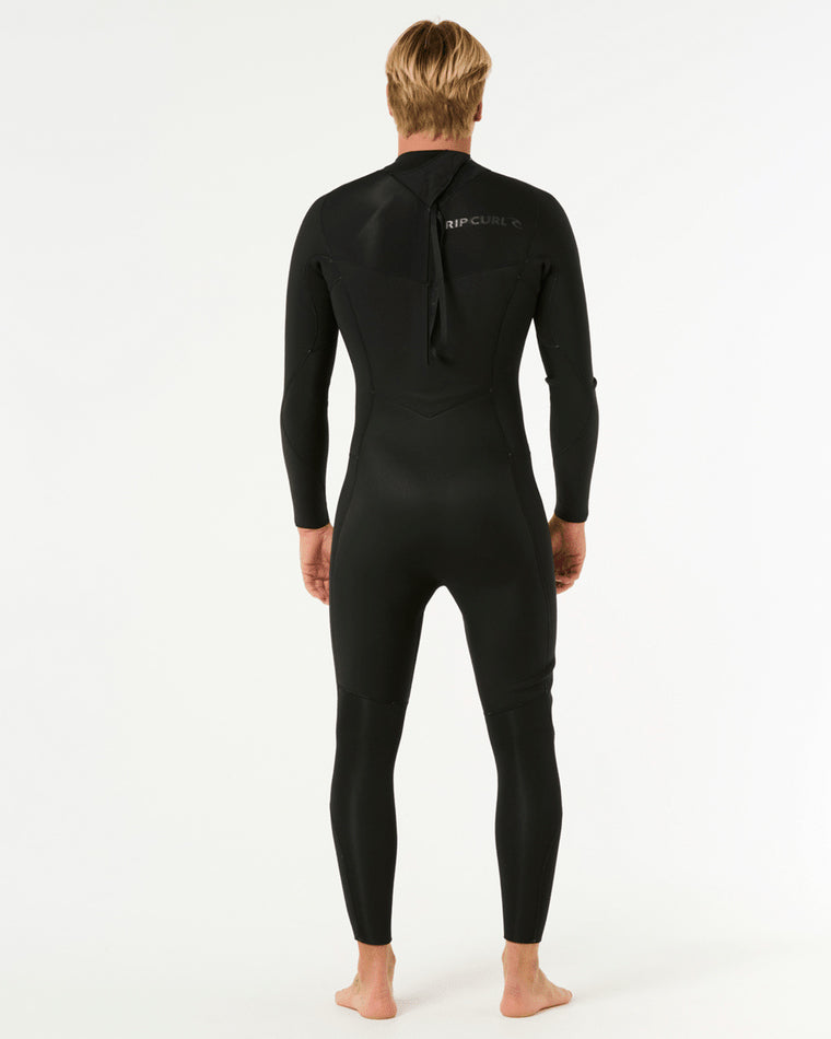 Back view of a male model wearing a black Rip Curl full-length wetsuit with a back zipper and logo detailing on the upper back