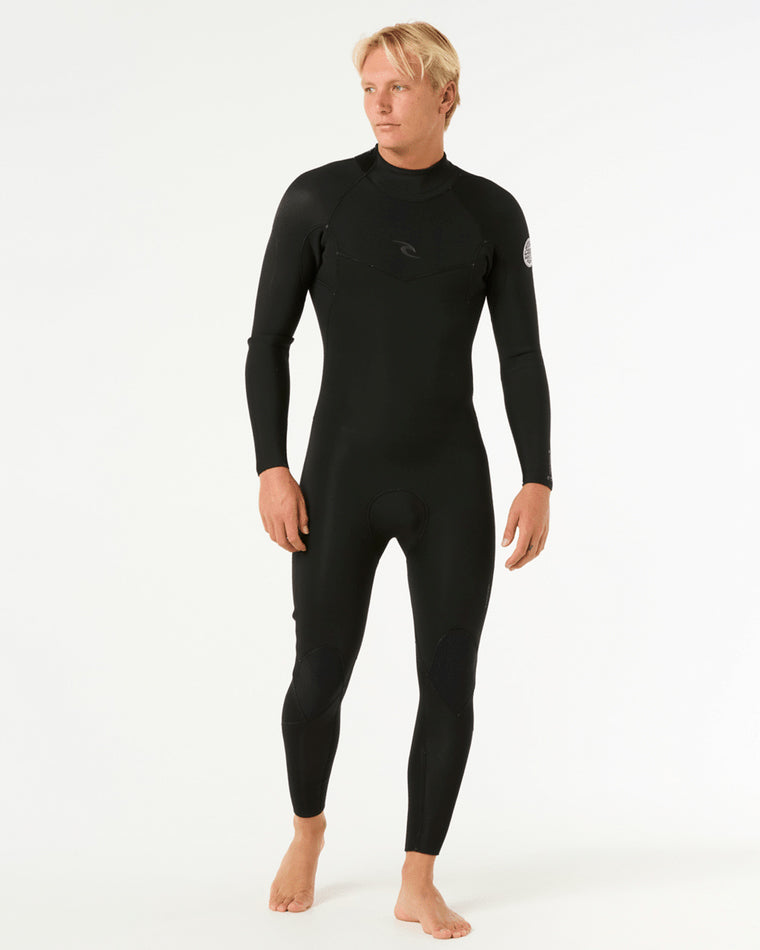 Male model wearing a black Rip Curl full-length wetsuit with a chest zip entry and logo detailing on the chest and sleeve.