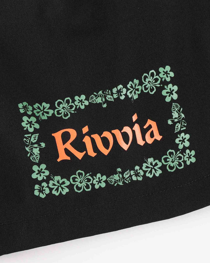 Close up of Rivvia floral logo print on black shorts