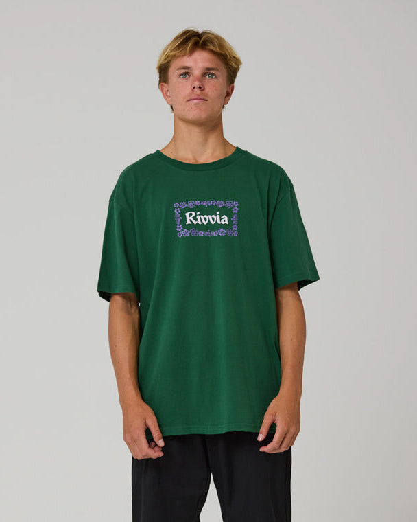 Model wearing green Rivvia t-shirt with purple floral border, relaxed fit and short sleeves