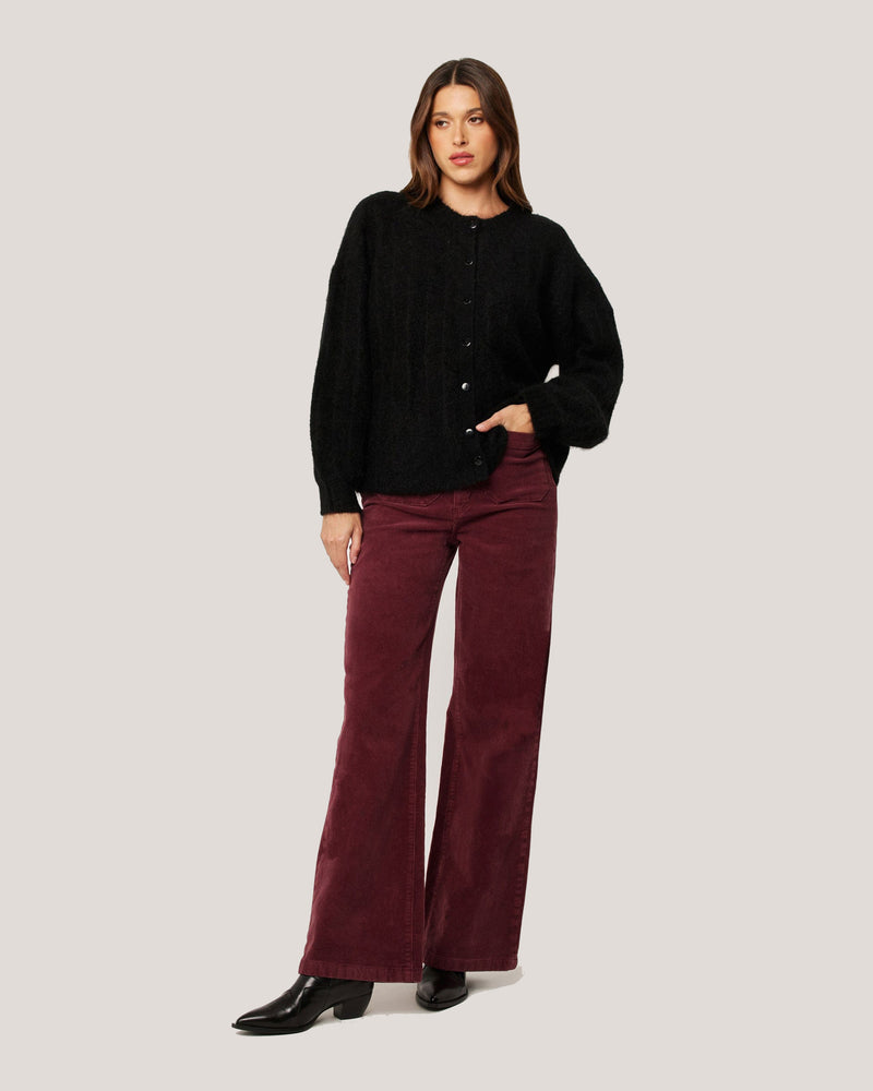 Burgundy cord pants styled with black knit jumper and boots for a chic winter outfit