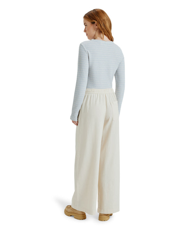 Back view of cream wide-leg pants with elastic waistband and rear pocket.