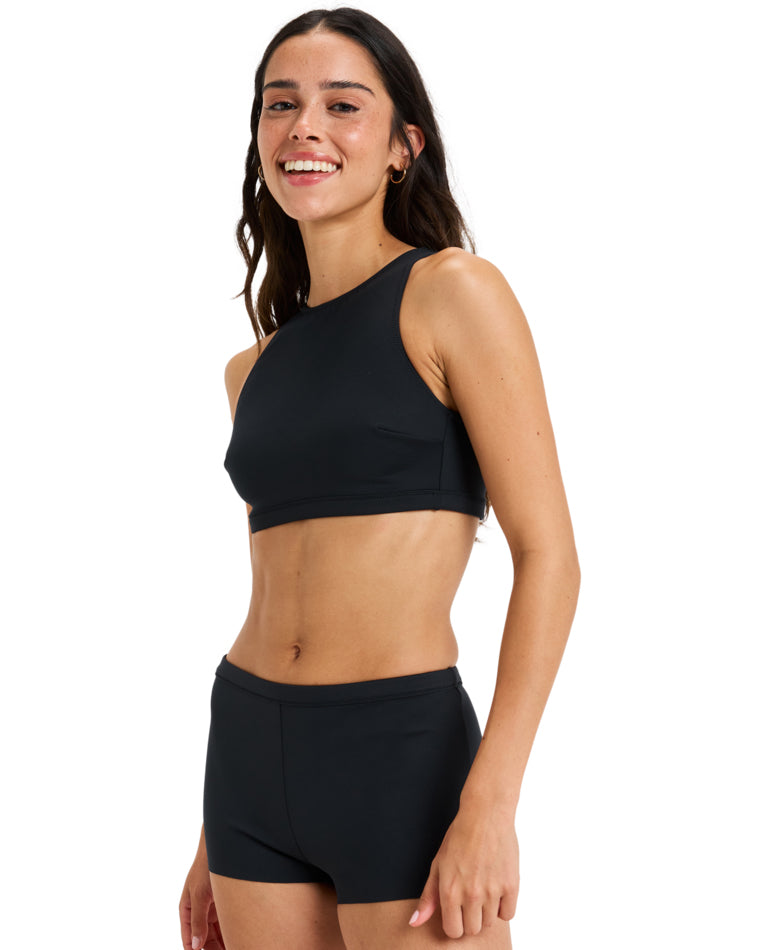 Side view of black Roxy swimwear featuring a fitted high neck top and short bottoms.
