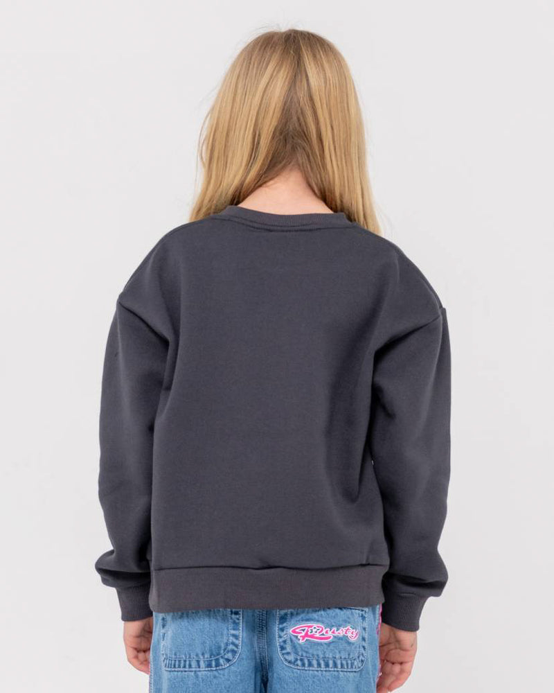 Back view of a girl wearing a dark grey oversized sweatshirt with a relaxed fit, paired with blue jeans featuring a pink logo patch.