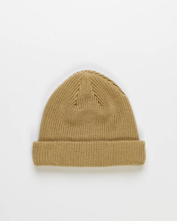 Beige knitted beanie with a folded cuff, displayed against a white background.