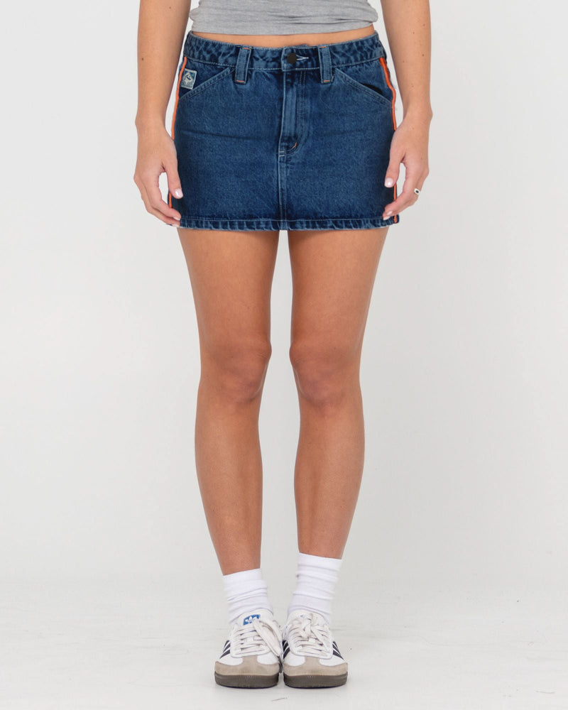 Front view of a denim skirt with a button-up closure, pockets, and an orange accent stripe on the side.