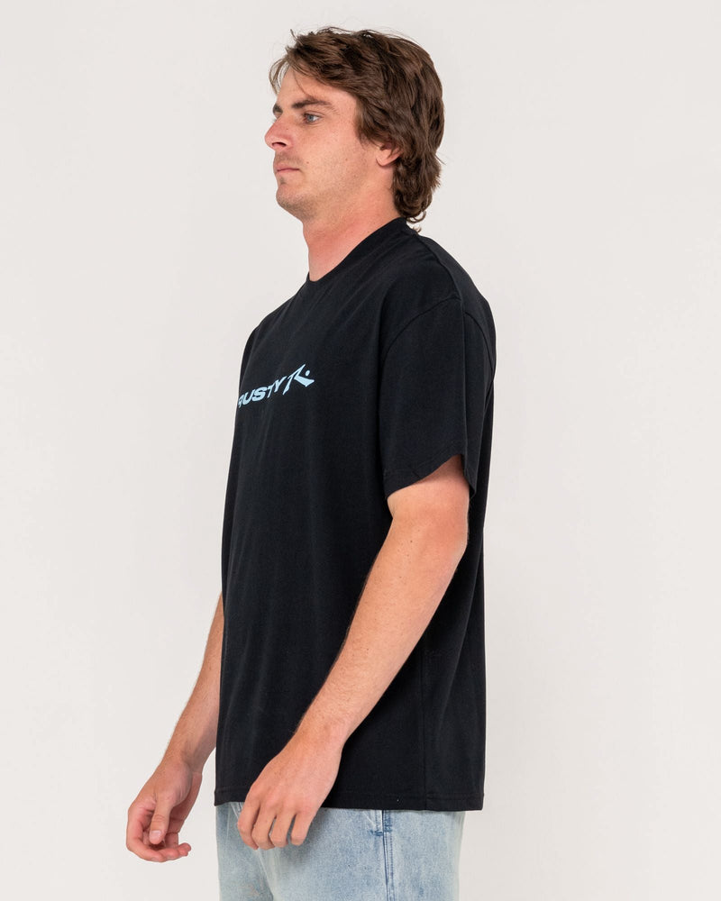 Side view of black Rusty t-shirt with blue chest logo, styled with light denim