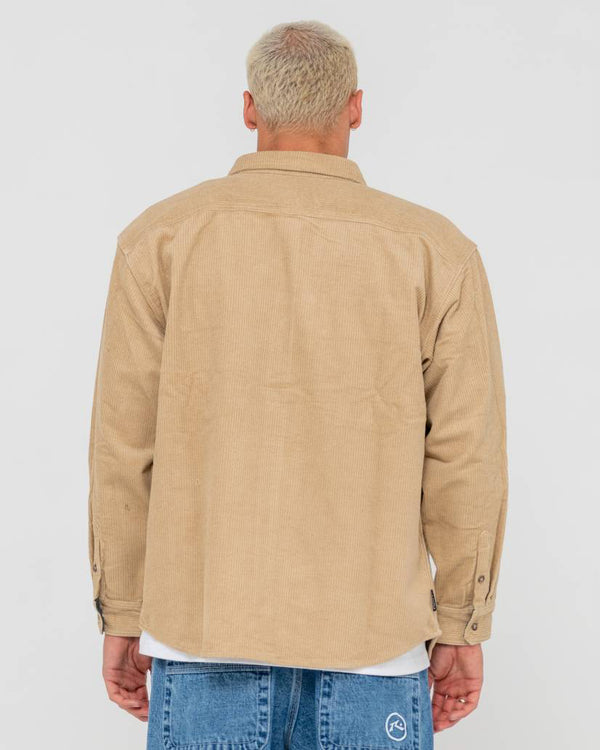 Back view of a men's beige corduroy button-up jacket with long sleeves, worn over a white t-shirt and blue jeans.