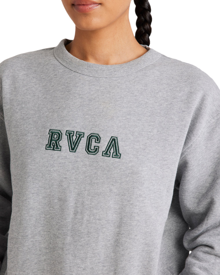 Close-up of a grey RVCA fleece crew featuring a green embroidered logo on the chest, showcasing soft fabric and classic design.