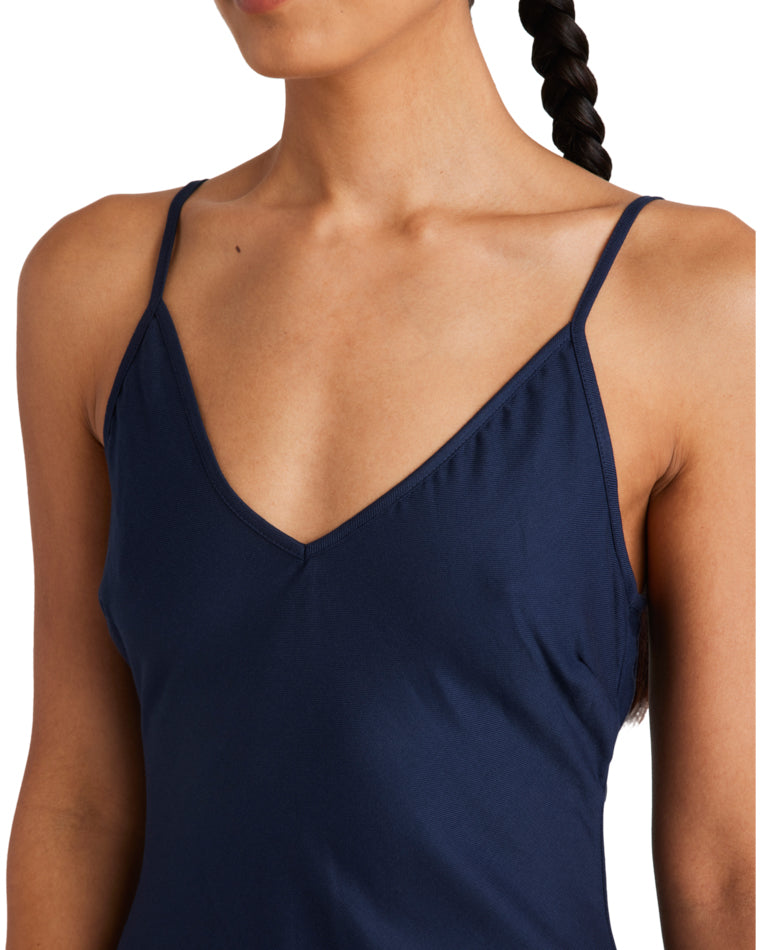 Close-up of a navy blue slip dress featuring a delicate V-neckline and thin spaghetti straps for an elegant, minimalist look.