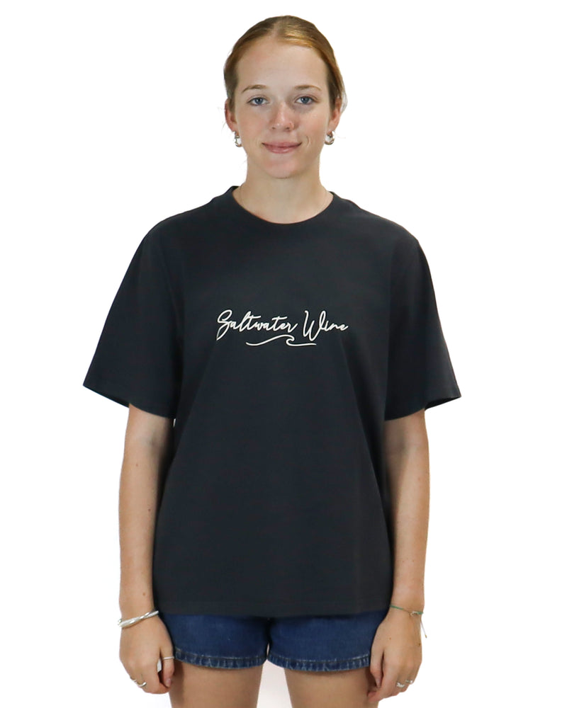 Black oversized t-shirt with "Saltwater Wine" script logo, paired with high-waisted denim shorts for a casual look.